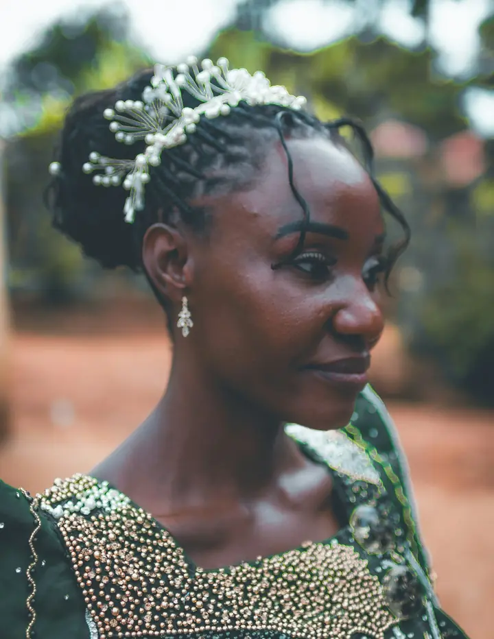 Bride in a green beaded gown and pearl hairpiece